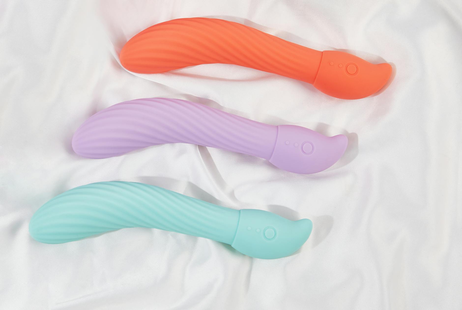 Una giovane coppia che si abbraccia teneramente, tenendo in mano un vibratore blu moderno, simboleggiando l'intimità contemporanea condivisa.