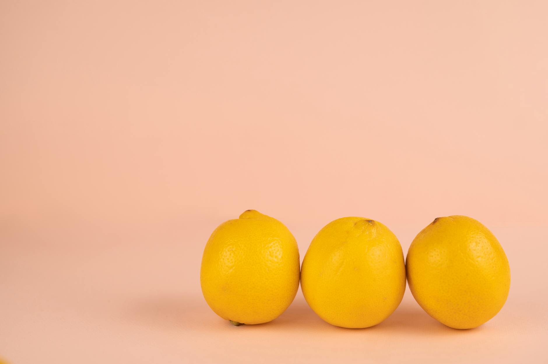 File di limoni gialli brillanti su sfondo pastello, che rappresentano freschezza e rinnovamento nel desiderio